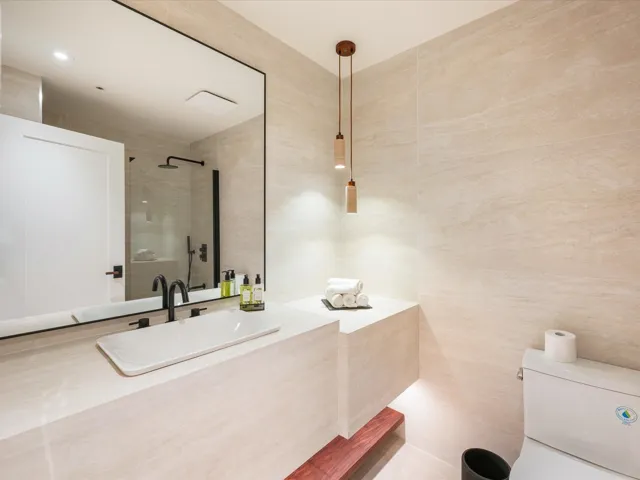 Full bathroom featuring tile walls, tiled shower, and vanity