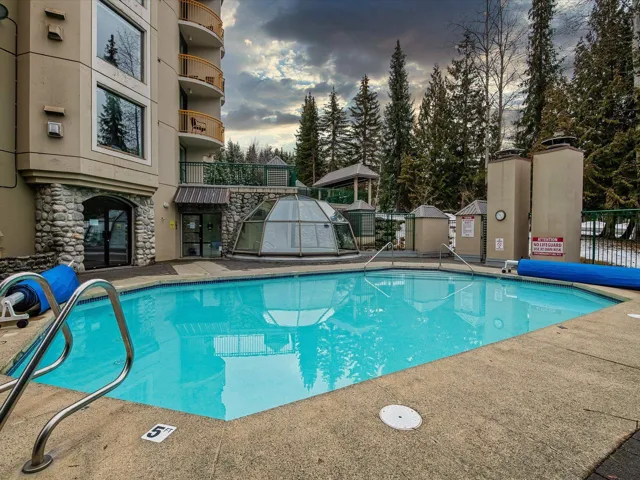 Pool at dusk featuring a community pool and a patio