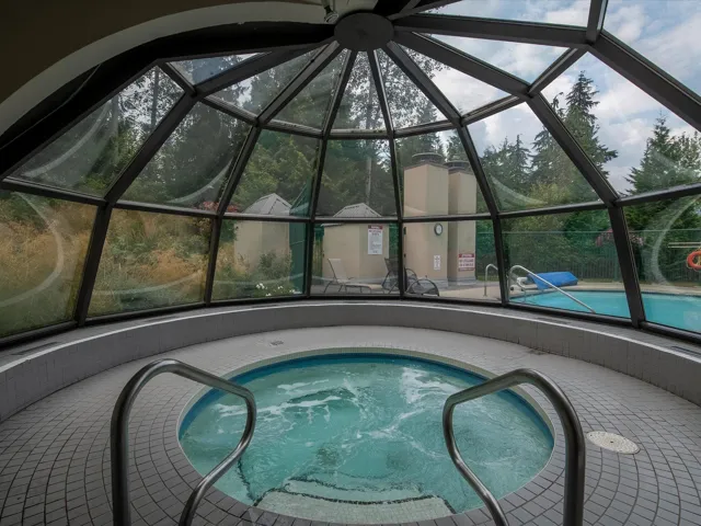 View of swimming pool with a community hot tub, a sunroom, and a lanai