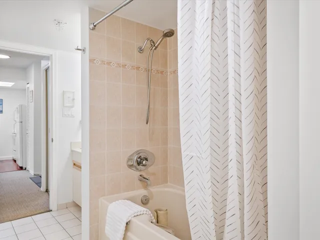 Bathroom with shower / bath combo, tile patterned flooring, and vanity