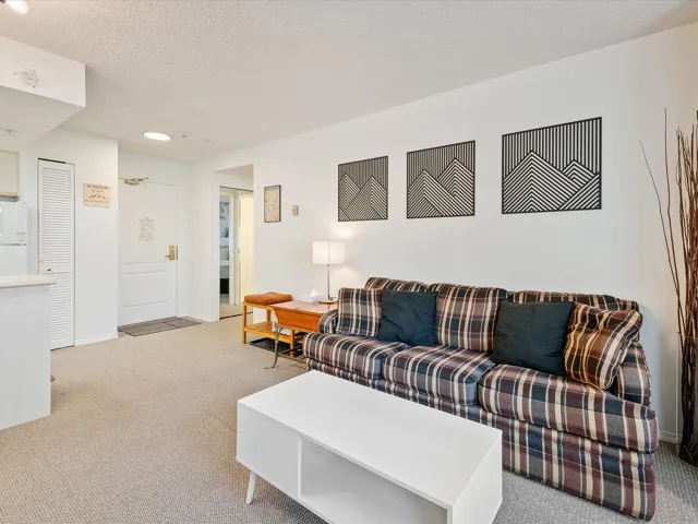 Carpeted living area featuring a textured ceiling and baseboards