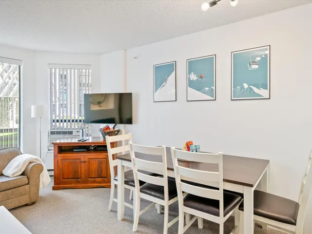 Dining space featuring a textured ceiling, light colored carpet, and cooling unit