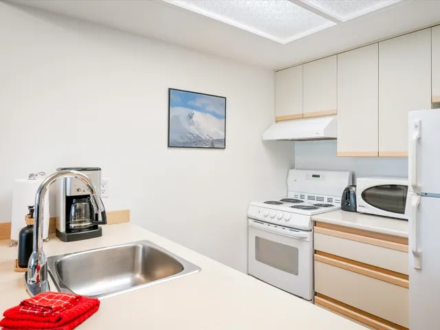 Kitchen with white appliances, light countertops, and under cabinet range hood