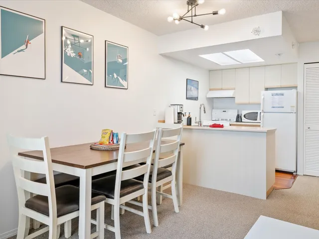 Dining room featuring a chandelier, a textured ceiling, light carpet, and a skylight