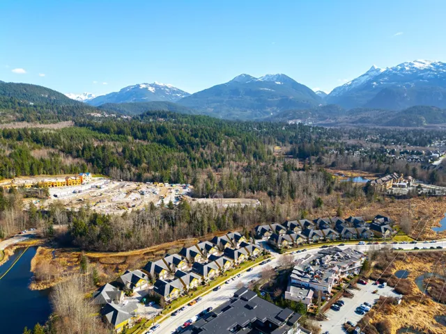 Birds eye view of property with a view of trees and a water and mountain view