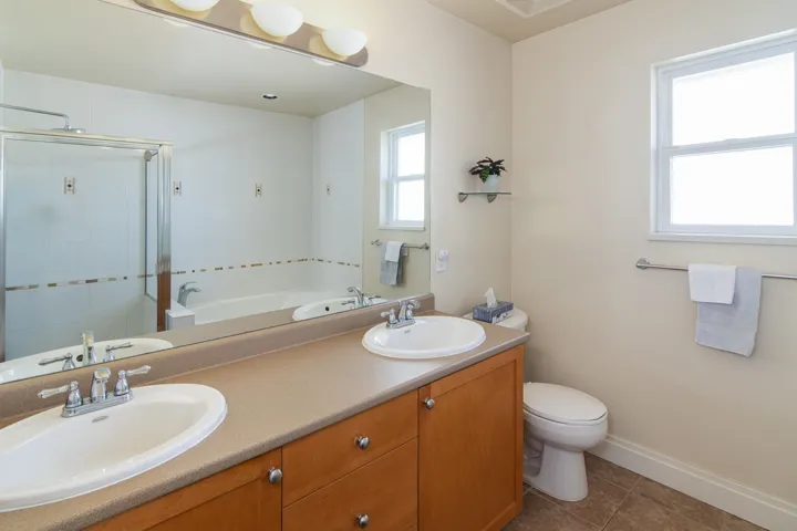 Full bathroom with a shower stall, toilet, tile patterned floors, and a sink