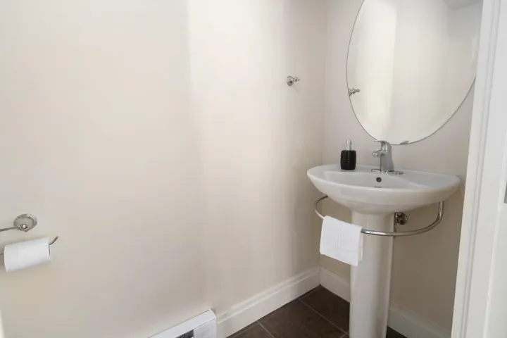Bathroom featuring tile patterned floors, baseboards, baseboard heating, and a sink