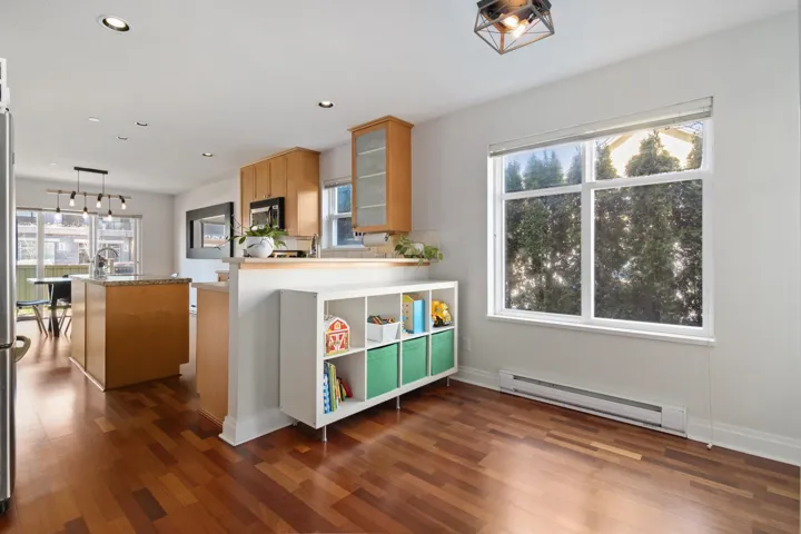 Kitchen featuring an island with sink, glass insert cabinets, dark wood-style floors, recessed lighting, and a baseboard radiator