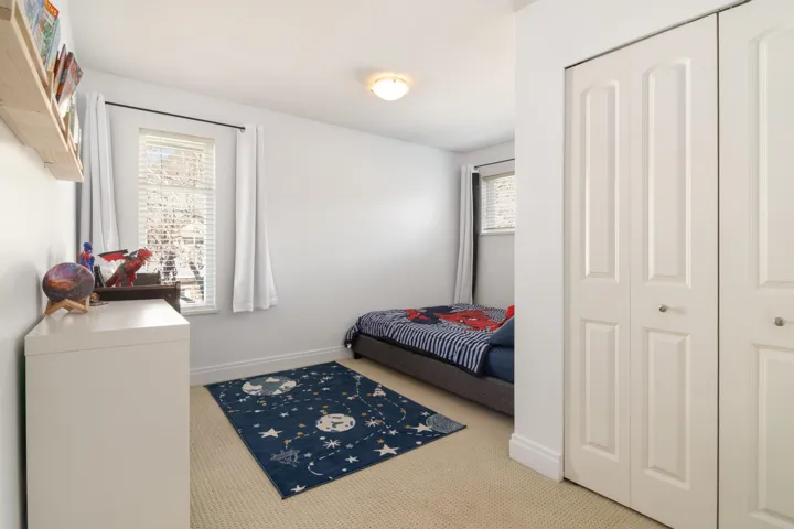 Carpeted bedroom featuring a closet and baseboards