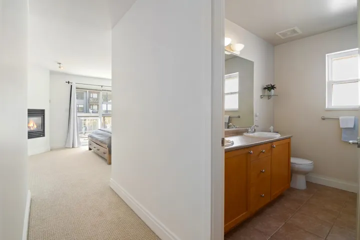 Bathroom featuring visible vents, a sink, a glass covered fireplace, double vanity, and baseboards