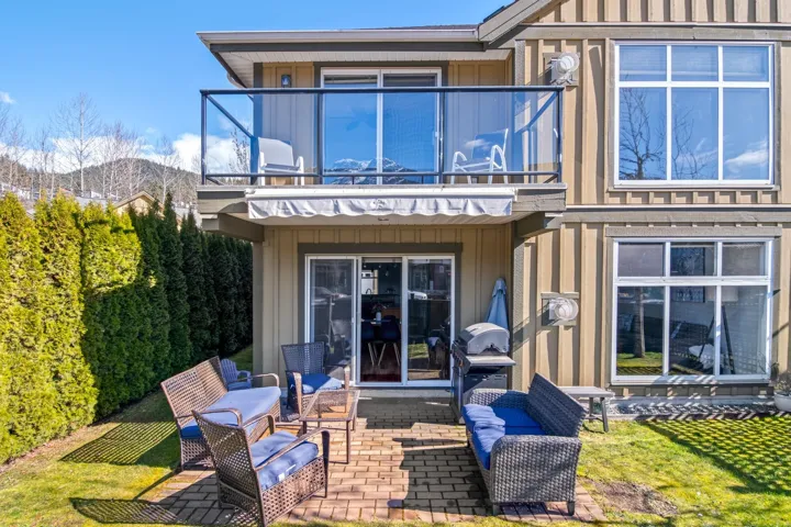 Rear view of house with a balcony, a patio area, board and batten siding, and a mountain view