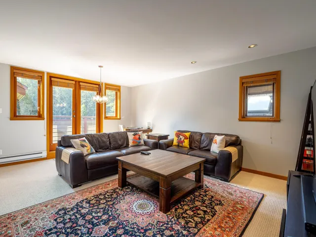 Living room featuring recessed lighting, a baseboard radiator, a chandelier, and light carpet