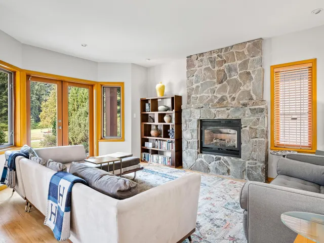 Living room with a fireplace, wood finished floors, french doors, and recessed lighting