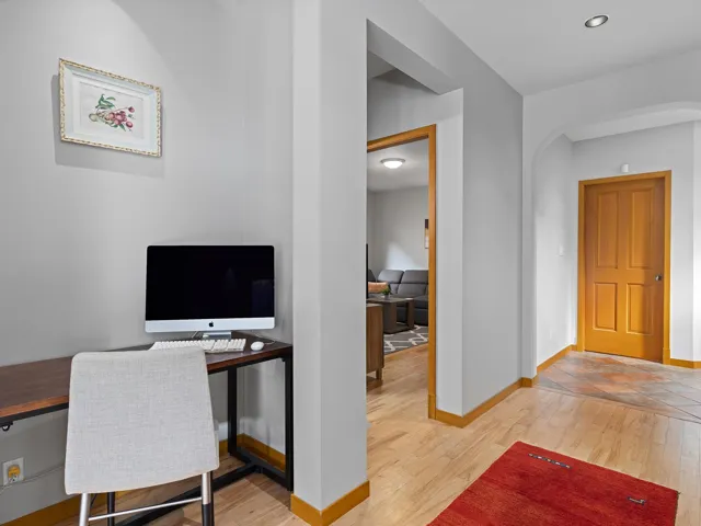 Office space with light wood-style flooring and arched walkways