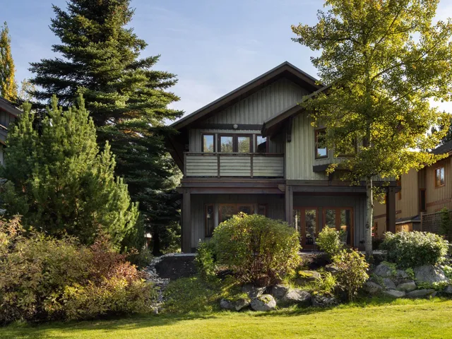 Back of house with a balcony and a yard