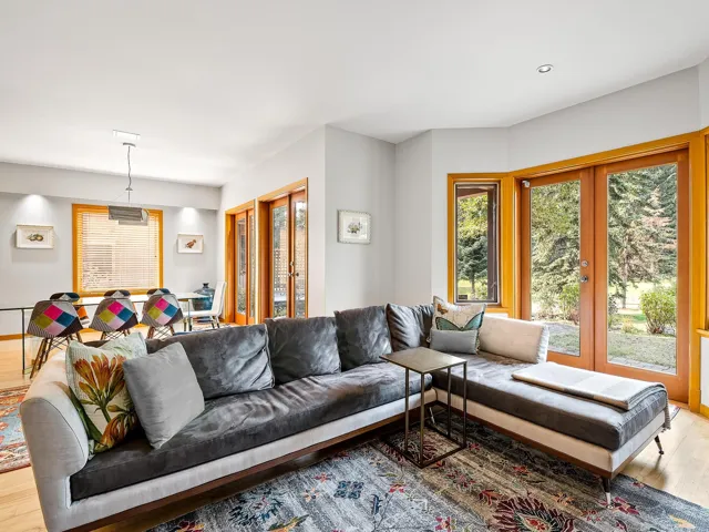Living room with light wood-style floors, healthy amount of natural light, and french doors