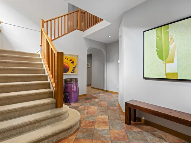 Stairs featuring arched walkways and stone finish floors