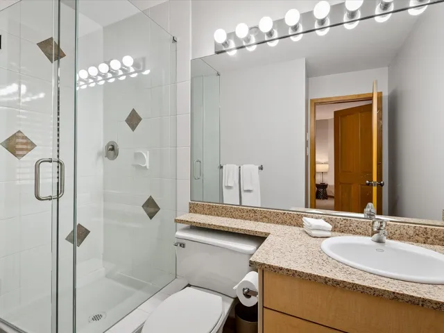 Full bathroom with vanity and a shower stall