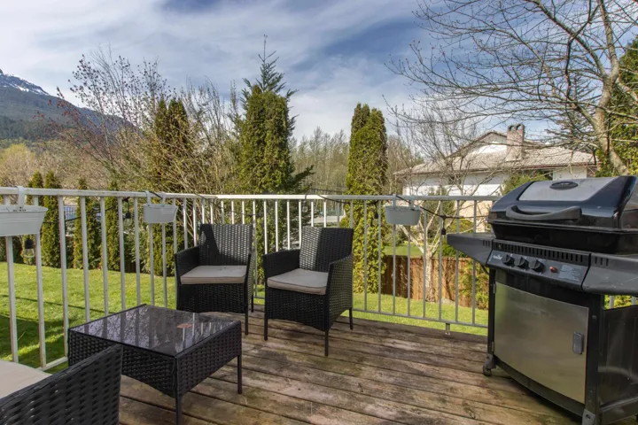 Deck with a lawn, a grill, and a mountain view