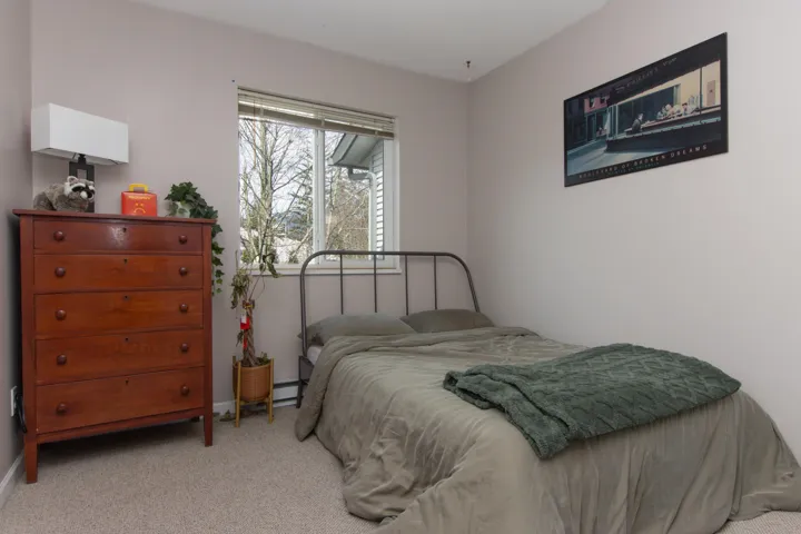Carpeted bedroom with a baseboard radiator and baseboards