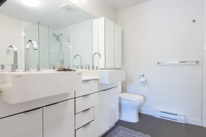 Full bath featuring tile patterned flooring, toilet, a sink, and a stall shower