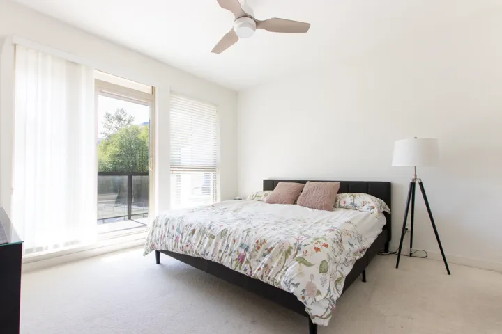 Bedroom featuring a ceiling fan, baseboards, and light colored carpet