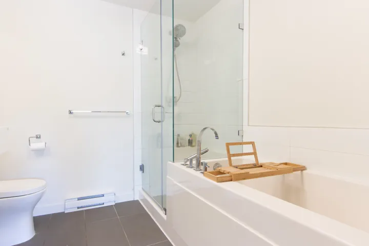 Full bathroom with tile patterned flooring, toilet, a baseboard heating unit, a garden tub, and a stall shower