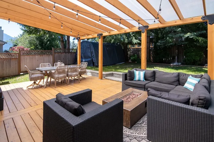 Deck with an outdoor living space with a fire pit, outdoor dining area, and a fenced backyard