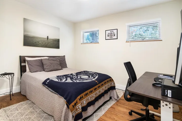 Bedroom featuring wood finished floors and an office area