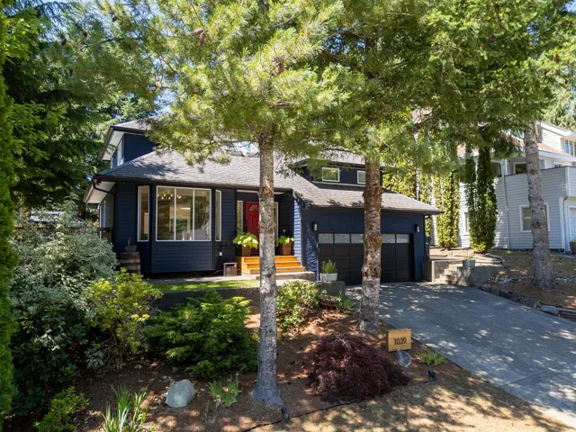 View of front of home with driveway and a shingled roof
