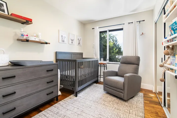 Bedroom featuring a nursery area and wood finished floors