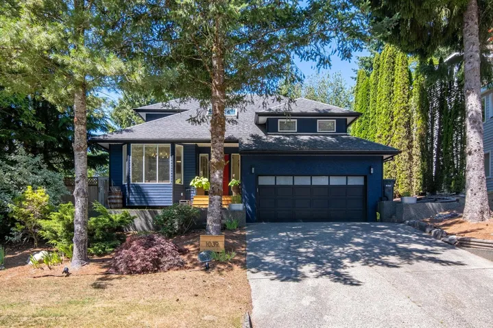 View of front of house featuring concrete driveway, an attached garage, and roof with shingles