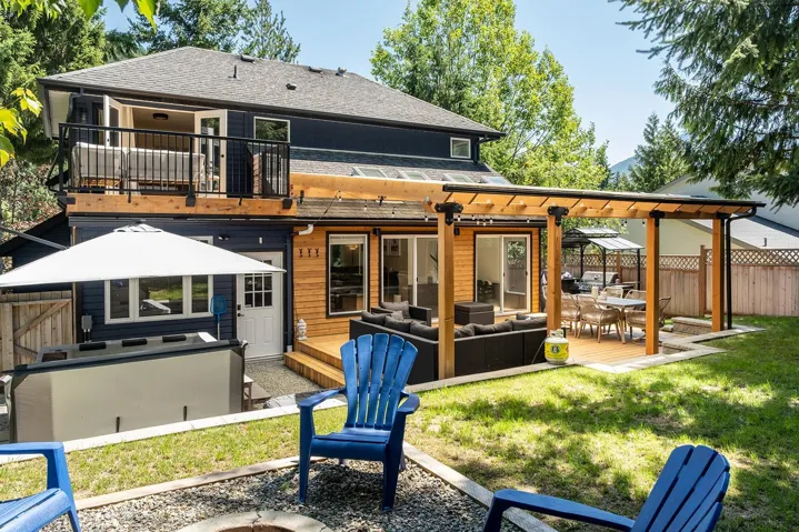 Rear view of house with an outdoor living space, a deck, a shingled roof, and outdoor dining area