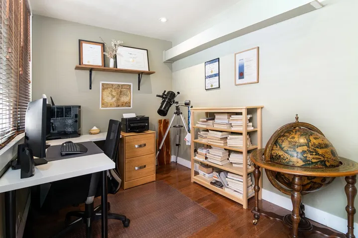 Home office with dark wood finished floors and recessed lighting
