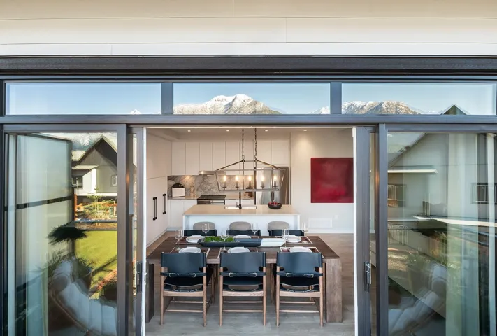 Dining area view of a mountainous background, stainless steel appliances, and a chandelier