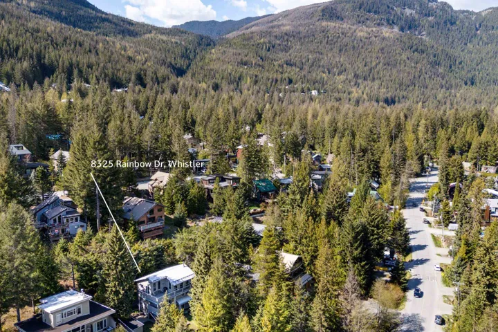 Aerial perspective showcasing a property nestled within a densely forested mountain landscape