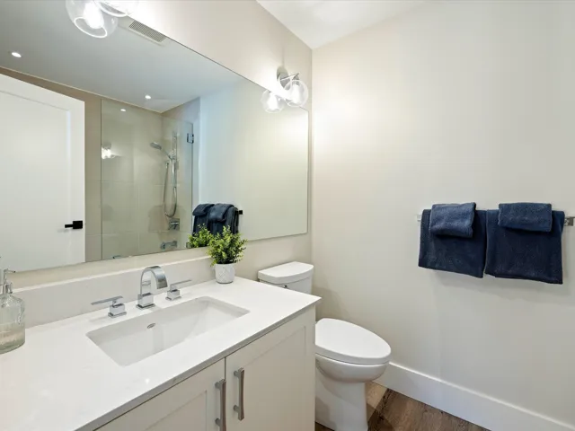 Full bath with wood finished floors, vanity, a tile shower, and recessed lighting