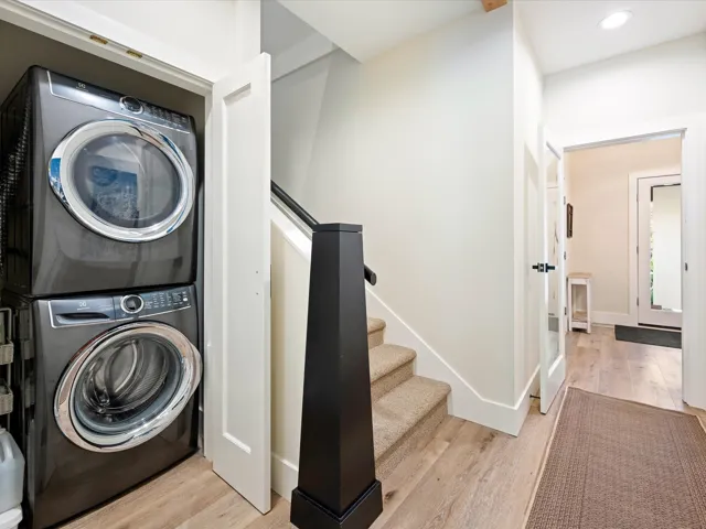 Washroom featuring estacked washer and dryer, light wood-style flooring, and recessed lighting