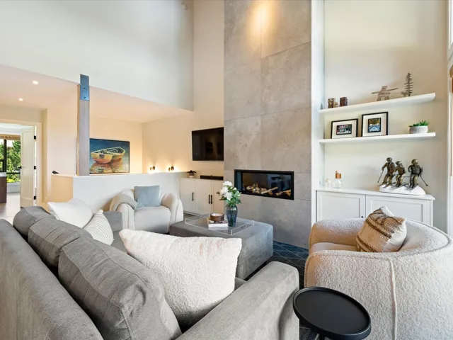 Living room featuring a towering ceiling, a tiled fireplace, and recessed lighting