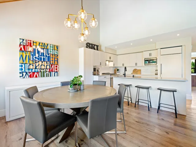 Dining space with a high ceiling, recessed lighting, light wood-style flooring, and a chandelier