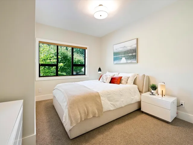 Bedroom with light colored carpet and baseboards