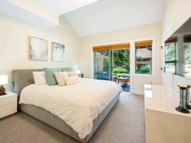 Bedroom featuring access to outside, lofted ceiling, and light carpet