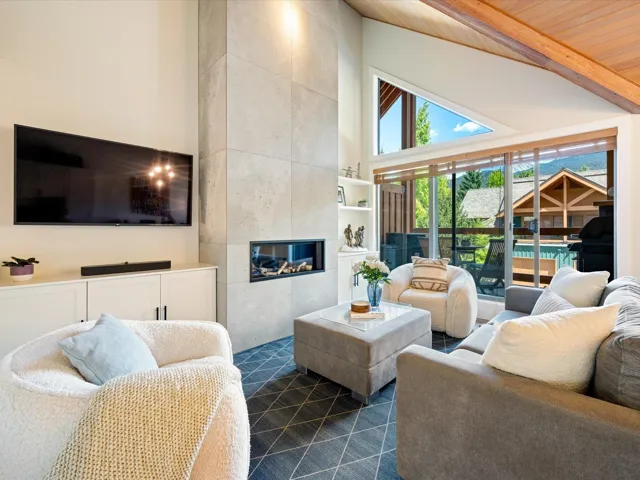 Living room with high vaulted ceiling, a tile fireplace, and a wood ceiling with exposed beams
