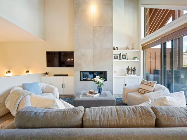Living room featuring a high ceiling, wood finished floors, and a fireplace