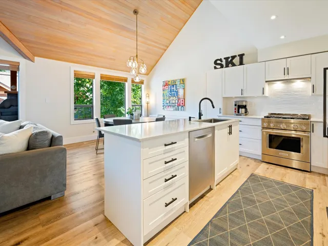 Kitchen with appliances with stainless steel finishes, healthy amount of natural light, wood ceiling, open floor plan, and white cabinets
