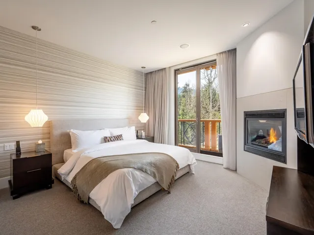 Bedroom with carpet and a glass covered fireplace