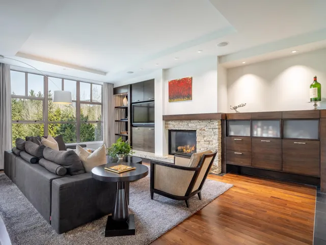 Living area with a fireplace, wood finished floors, recessed lighting, and a tray ceiling