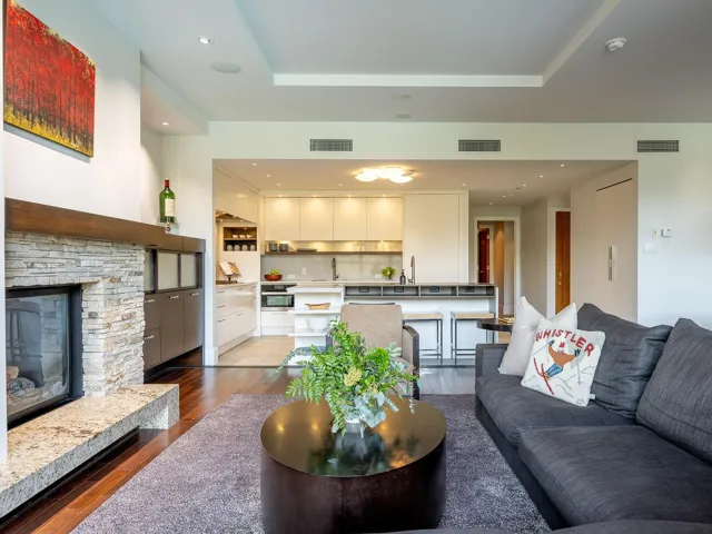 Living area with a fireplace, dark wood finished floors, recessed lighting, and a tray ceiling