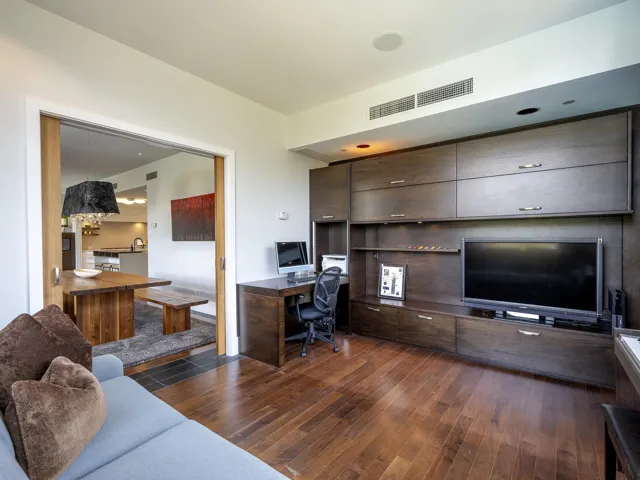 Office space featuring built in desk and dark wood-style flooring