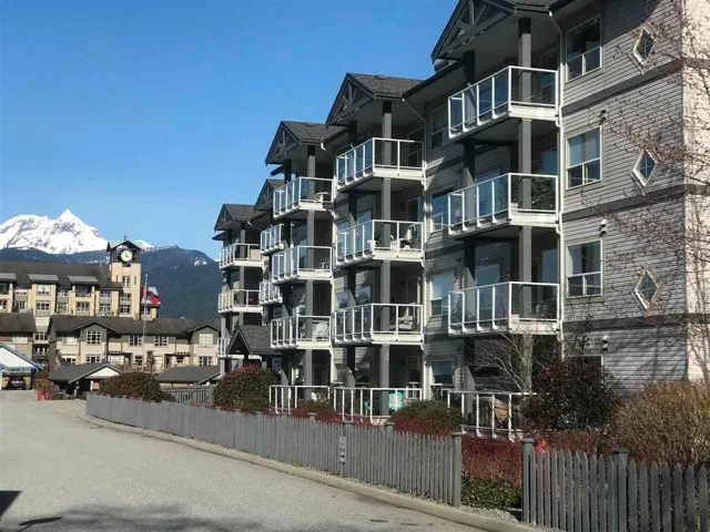 View of building exterior featuring fence and a mountain view